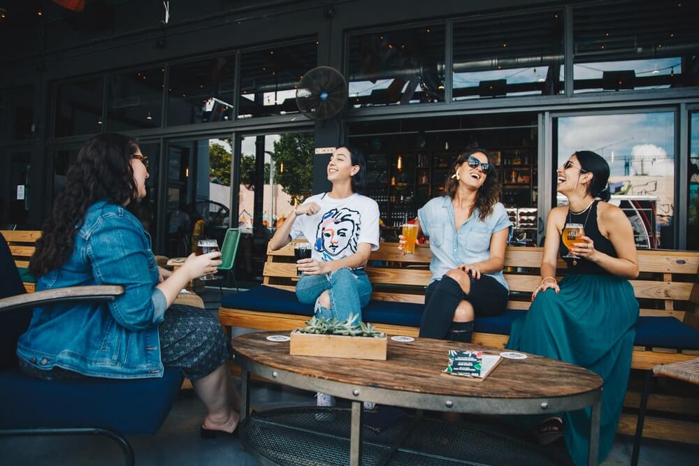 Four Women Chatting While Sitting On Bench 1267697