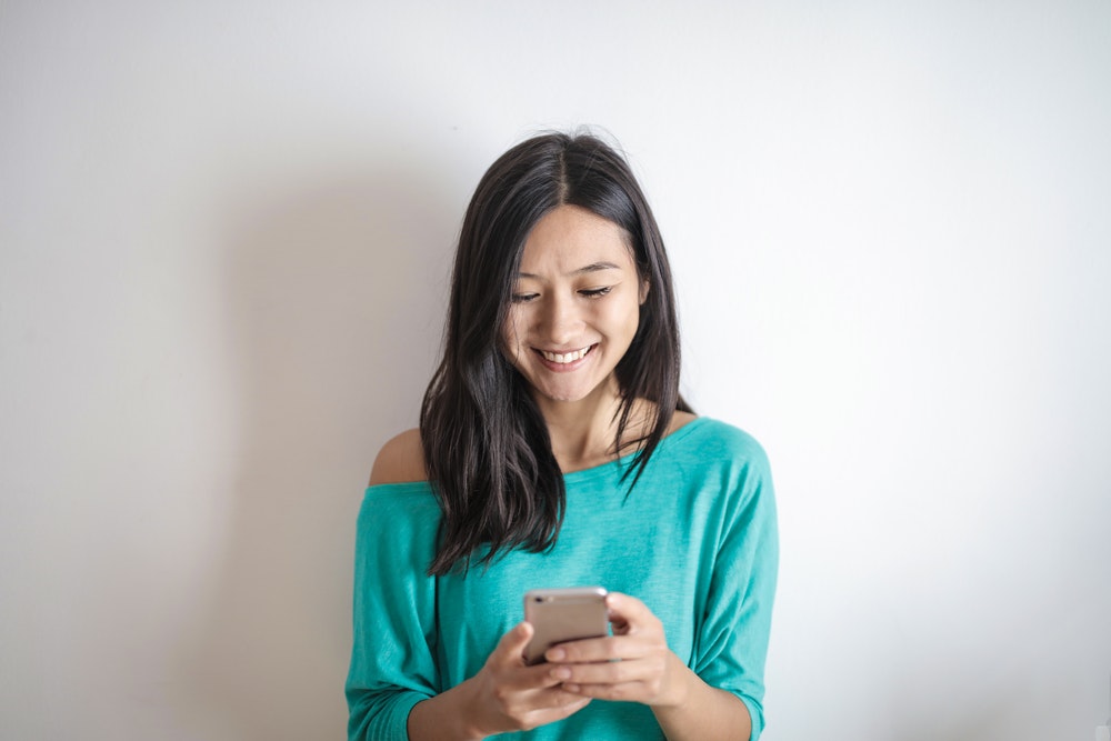 Woman Laughing While Texting